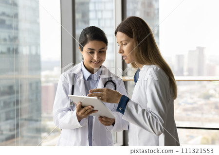 Multiethnic Indian and Caucasian doctor colleague women consulting medical records 111321553