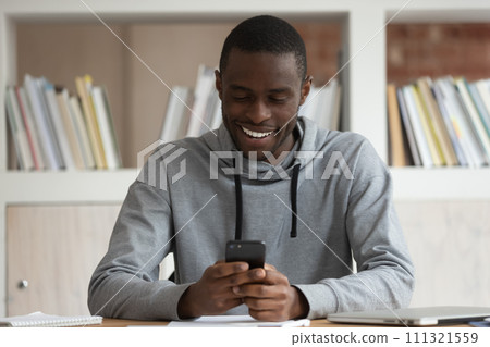 Smiling biracial male student have fun using smartphone 111321559