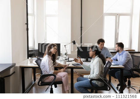 Pairs of busy multiethnic office colleagues talking at shared workplace 111321568