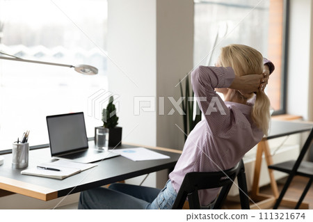 Calm young woman relax at desk at home office Calm young woman relax at desk at home office 111321674