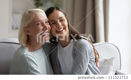 Happy mature grandmother and granddaughter hugging, having fun 111321713