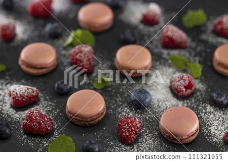 macaroons of different colors on a black background 111321955
