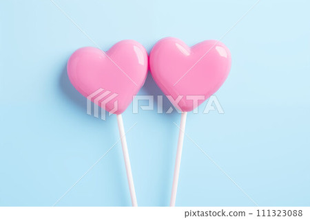 AI-generated content. Two pink heart-shaped lollipops on blue. AI-generated content. Two pink heart-shaped lollipops on blue. 111323088