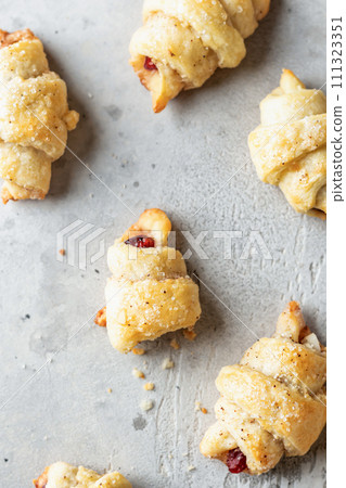 Homemade bagel cookies with dried fruits and walnuts on gray background top view. Sweet croissant cookies 111323351