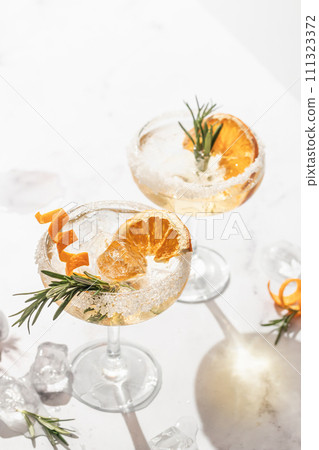 Two sidecar cocktails with sugar rim on white marble table. Festive party composition 111323372