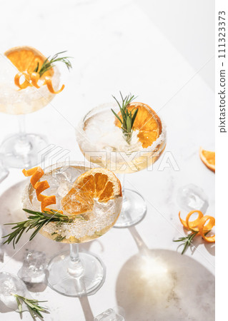 Sidecar cocktail with a sugar rim on white marble table. Festive party composition Sidecar cocktail with a sugar rim on white marble table. Festive party composition 111323373