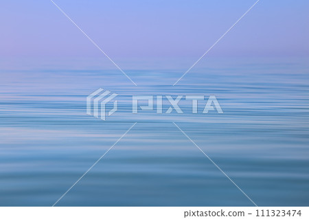Calm sea wavy surface of the sea under a clear sky close-up. Blue and purple background. Calm sea wavy surface of the sea under a clear sky close-up. Blue and purple background. 111323474