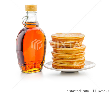Pancakes and maple syrup in bottle isolated on white backgorund. Pancakes and maple syrup in bottle isolated on white backgorund. 111323525