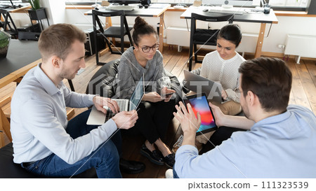 Multiracial colleagues work on gadgets at office meeting 111323539