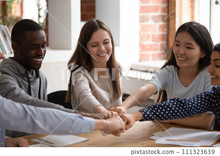 Smiling multiracial students join hands showing unity Smiling multiracial students join hands showing unity 111323639