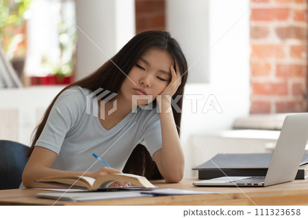 Exhausted Asian female student feel bored studying Exhausted Asian female student feel bored studying 111323658