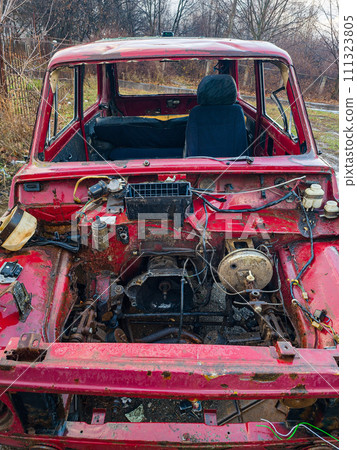 An old burnt-out red car in close-up. The concept of danger and disaster. 111323805