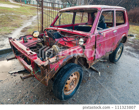 Old destroyed car is red. The concept of danger and disaster. An abandoned car on the asphalt. 111323807