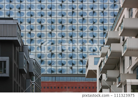 Part of the Dockland office building in Hamburg by architect Hadi Teherani. The windows of the building reflecting the sky with clouds and creating a surreal view. Part of the Dockland office building in Hamburg by architect Hadi Teherani. The windows of the building reflecting the sky with clouds and creating a surreal view. 111323975