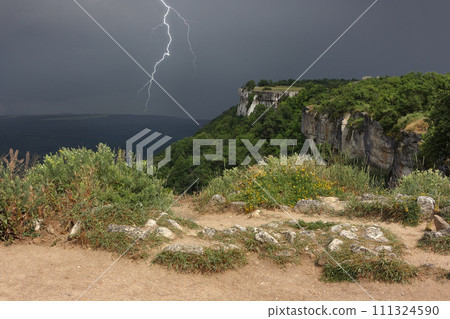 Thunderstorm is approaching over plateau of Crimean mountains. The dividing line of solar weather and stormy weather in Crimea. Thunderstorm is approaching over plateau of Crimean mountains. The dividing line of solar weather and stormy weather in Crimea. 111324590