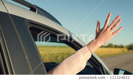 girl rides car with her hand out window, girl traveling by car, looking cheerfully out car window, outdoor entertainment, enjoying picturesque landscape sunset, car road, breeze your hair, summer trip girl rides car with her hand out window, girl traveling by car, looking cheerfully out car window, outdoor entertainment, enjoying picturesque landscape sunset, car road, breeze your hair, summer trip 111324622