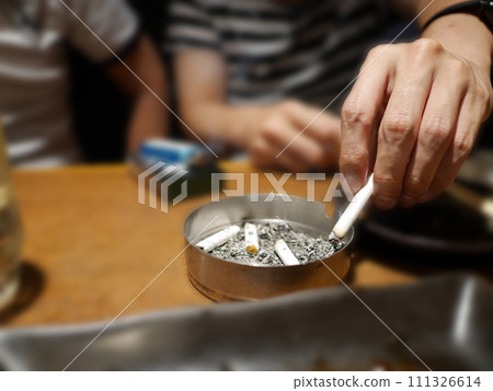 吸菸者將煙灰倒入煙灰缸 吸菸者將煙灰倒入煙灰缸 111326614