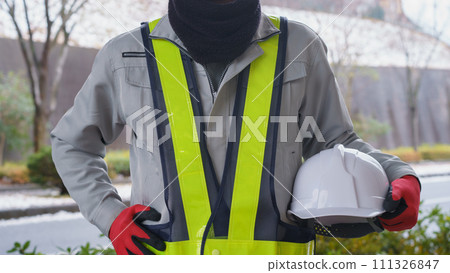 在雪景中，一名穿著工作服的男子使用頸部保暖器來保護自己免受寒冷 111326847