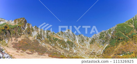 A panoramic view of the majestic Central Alps seen from Senjojiki Cirque against a blue sky. A panoramic view of the majestic Central Alps seen from Senjojiki Cirque against a blue sky. 111326925