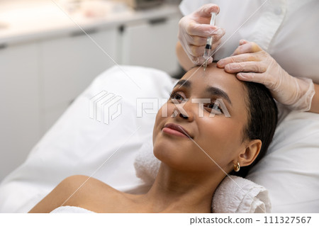 Dark-haired woman having vitamin face injections at the beauty salon Dark-haired woman having vitamin face injections at the beauty salon 111327567
