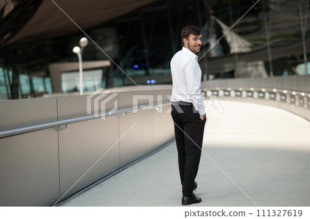 Young tall man in white shirt walking and smiling Young tall man in white shirt walking and smiling 111327619