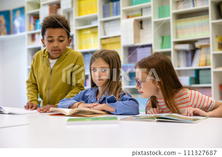 Group of kids sitting studying in elementary school library. 111327687