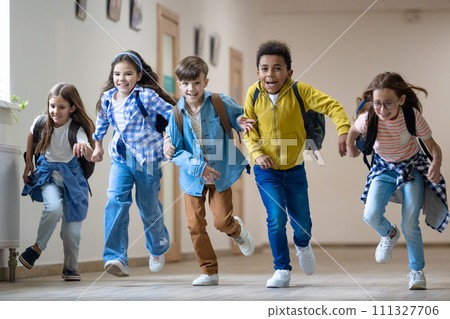 Group of elementary school kids running in school corridor. 111327706