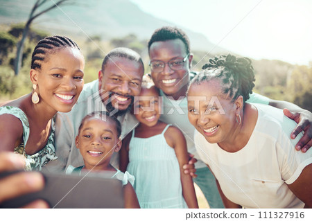 Black family taking a selfie with happy children in nature together in fun natural outdoors in summer. Freedom, smile and senior woman with African kids smiling for phone camera on a holiday vacation 111327916