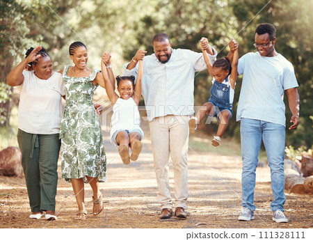 Happy black family bonding and having fun at a park together, laughing and playful holding hands on active walk in nature. African American children enjoy time outdoors with parents and grandparents 111328111