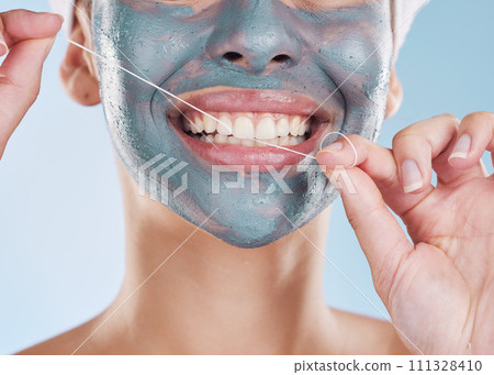 Dental, face mask and woman flossing her teeth for healthy and strong teeth in a studio portrait with a blue background. Girl cleaning her mouth, face and skin with beauty self care and oral hygiene Dental, face mask and woman flossing her teeth for healthy and strong teeth in a studio portrait with a blue background. Girl cleaning her mouth, face and skin with beauty self care and oral hygiene 111328410