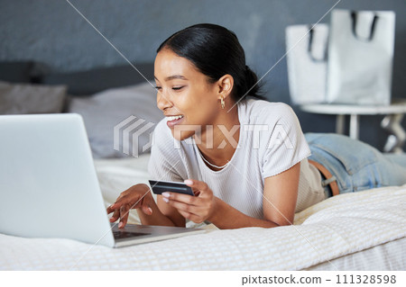 Credit card, online shopping and fintech woman with laptop, payment and financial internet or web banking. Economy, finance and buying and girl ordering products on website or app on home bed. 111328598