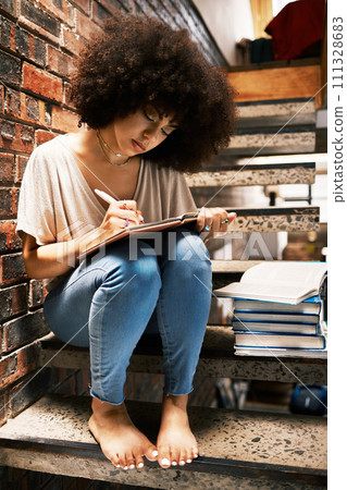 Learning, studying and black woman writing notes in a book, notebook or textbook on house steps. African girl, education and student with notepad, paper or books with a pen or pencil at home. Learning, studying and black woman writing notes in a book, notebook or textbook on house steps. African girl, education and student with notepad, paper or books with a pen or pencil at home. 111328683