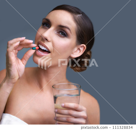 Woman, pill and water for healthcare, medication or drugs on a blue studio background. Female person. brunette or model with antibiotic, pharmaceuticals or vitamin supplement for wellness on mockup Woman, pill and water for healthcare, medication or drugs on a blue studio background. Female person. brunette or model with antibiotic, pharmaceuticals or vitamin supplement for wellness on mockup 111328834