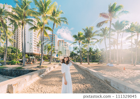 A woman walking on a beach overseas 111329045