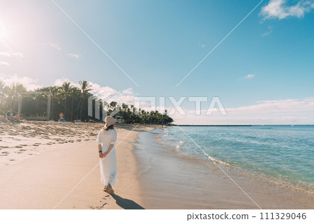 A woman walking on a beach overseas 111329046