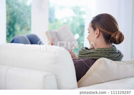 Woman, book and reading in home from the back for story, novel and learning knowledge on sofa in living room. Lady, fiction books and relax on couch with literature, hobby and comfortable in lounge Woman, book and reading in home from the back for story, novel and learning knowledge on sofa in living room. Lady, fiction books and relax on couch with literature, hobby and comfortable in lounge 111329297