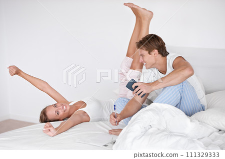 Conversation, love and young couple on bed in modern apartment relaxing together in the morning. Happy, calm and man and woman in marriage talking, bonding and writing in bedroom at home or house. Conversation, love and young couple on bed in modern apartment relaxing together in the morning. Happy, calm and man and woman in marriage talking, bonding and writing in bedroom at home or house. 111329333