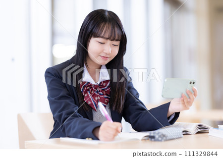 一邊看智慧型手機一邊學習的女高中生攝影合作:有明教育藝術專校 一邊看智慧型手機一邊學習的女高中生攝影合作:有明教育藝術專校 111329844
