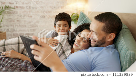 Family, bed and watching on tablet with a smile and cartoon with mom, dad and kid together. Bedroom, tech and education children program with mother, father and young boy with a youth movie at home 111329889