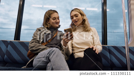Happy woman, friends and phone on train for social media, communication or networking in public transport. Female person or people talking with mobile smartphone for online search on railway ride 111330111