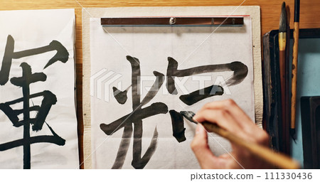 Man, calligraphy or hands of a Japanese artist in studio for art and script, letter with closeup for alphabet. Start, top or male person with tools, paintbrush and focus with traditional stationery Man, calligraphy or hands of a Japanese artist in studio for art and script, letter with closeup for alphabet. Start, top or male person with tools, paintbrush and focus with traditional stationery 111330436