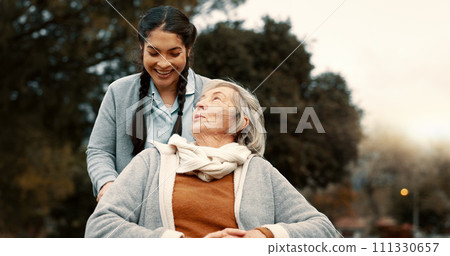 Senior woman, talking and outdoor with caregiver, nurse or healthcare service for person with a disability and wheelchair. Happy, face and elderly lady in park with care and support in retirement 111330657