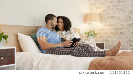 Couple, tablet and relax in home bedroom, laugh or morning with video, movie or meme for love, care or hug. Man, woman and digital touchscreen for typing, social network app or bond together in house 111331252