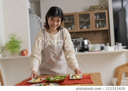 A woman cooking/serving a meal/a smiling housewife 111331420