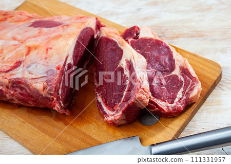 Pieces of raw boneless beef tenderloin on wooden background 111331957