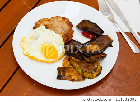 Just cooked meat cutlet with fried egg and vegetables Just cooked meat cutlet with fried egg and vegetables 111332092
