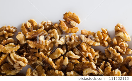 Dry peeled walnut in glass bowl on white background, nobody 111332113
