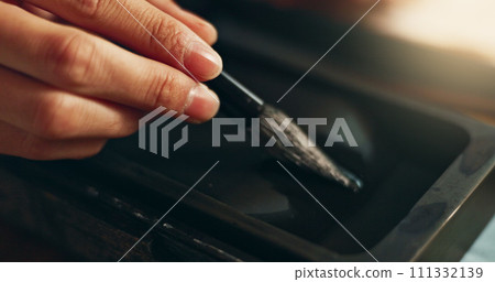 Hand, closeup of brush in ink for writing and calligraphy or ancient stationery for art and inkstone. Japanese creativity, black paint with paintbrush and person stroke with traditional vintage tools 111332139