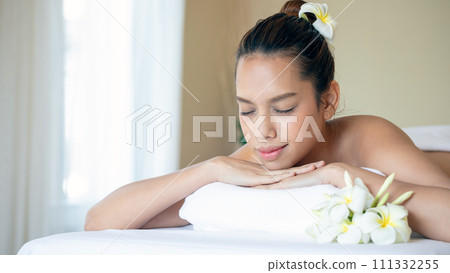 Young Asian Woman Enjoying Spa Treatment on a White Bed with copy space; Luxury Spa Day 111332255