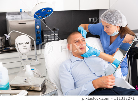 Woman beautician consulting male client before facial treatment 111332271